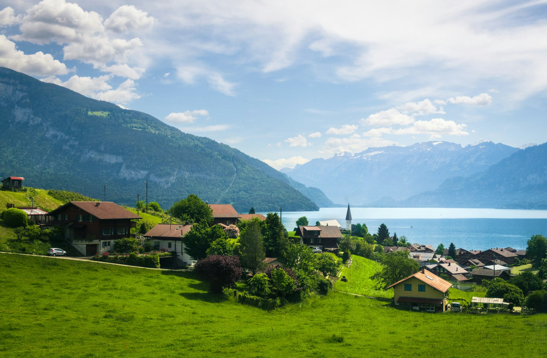 Alpine village with lake and mountains under blue sky